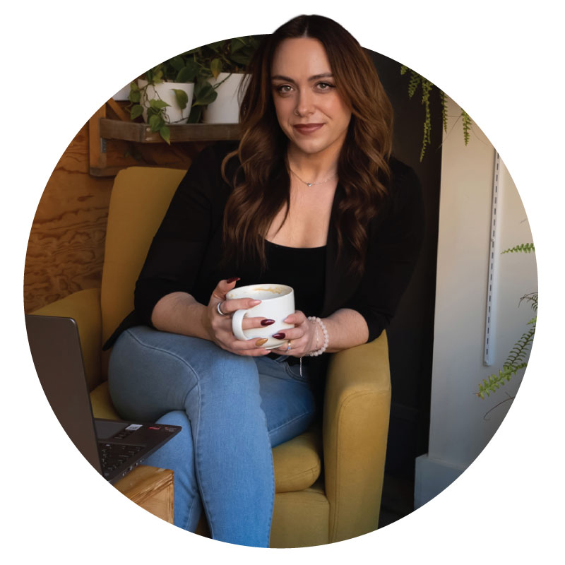 Kim Morgan, sitting in a yellow chair holding a coffee