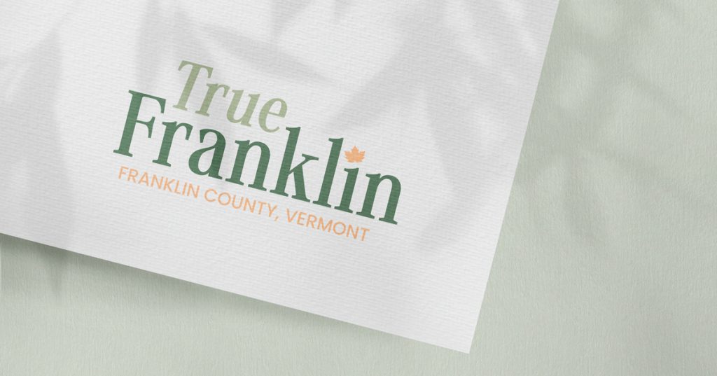 True Franklin – Franklin County, Vermont logo printed on white textured paper, featuring green serif typography and an orange maple leaf accent.