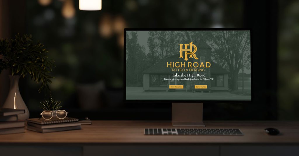 Large computer monitor displaying the High Road Tattoo & Piercing Website